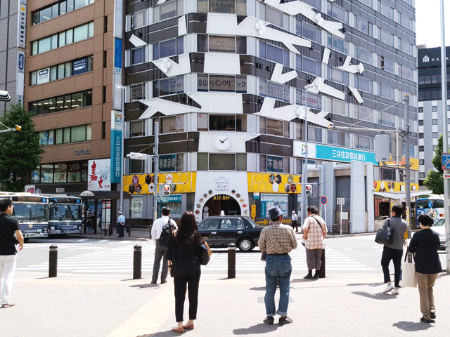 JRまたは名鉄金山駅の北口から外へ出て、右手側の交差点を三井住友信託銀行側へ渡ります。