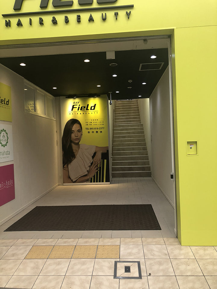 美容室レイフィールドさんの黄緑色の入口の階段を上ってください。